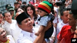 Calon presiden Indonesia Prabowo Subianto menggendong bayi dalam kampanye di Bandung (5/6). (AP/Kusumadireza) 