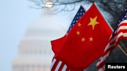 FILE - The People's Republic of China flag and the U.S. flag fly along Pennsylvania Avenue near the U.S. Capitol during Chinese President Hu Jintao's state visit in Washington, D.C., Jan. 18, 2011.