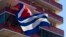 FILE - People watch a concert given by Puerto Rico's Olga Tanon, from a building flying a Cuban flag in Havana, Cuba. U.S. critics of Obama's opening to Cuba have complained the president has received little in return for restoring diplomatic relations with the former Cold War enemy.