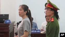 Prominent blogger Nguyen Ngoc Nhu Quynh, left, stands trial in the south central province of Khanh Hoa, Vietnam, June 29, 2017. She was accused of distorting government policies and defaming the Communist regime on her Facebook posts, her lawyer said.