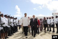 Venezuelan President Nicolas Maduro, left, talks with Prime Minister of St. Vincent and the Grenadines Ralph Gonsalves after Maduro's arrival at the Argyle International Airport in Argyle, St. Vincent, on Dec. 14, 2023. (Office of the Venezuelan President via AFP)