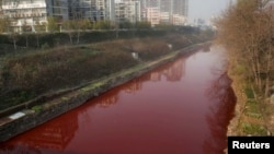 A view of red polluted water in the Jianhe River in Luoyang, Henan province, December 13, 2011. According to local media, the sources of the pollution are two illegal chemical plants discharging their production waste water into the rain sewer pipes. 