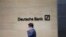 A man walks past the Deutsche Bank sign in London, July, 8, 2019. 
