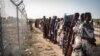 FILE - Women wait in a line for a food distribution by the United Nations World Food Program (WFP), in Gumuruk, South Sudan, June 10, 2021.