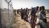 FILE - Women wait in a line for a food distribution by the United Nations World Food Program (WFP), in Gumuruk, South Sudan, June 10, 2021.