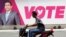A man rides a motorcycle past an image of Maldives President Abdulla Yameen on a road ahead of the presidential election in Male, Maldives, Sept. 19, 2018.