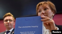 Marina Litvinenko, widow of ex-KGB agent Alexander Litvinenko, poses with a copy of "The Litvinenko Inquiry" with her son, Anatoly, during a news conference in London, Jan. 21, 2016. 