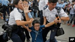 Seorang pengunjuk rasa prodemokrasi diamankan polisi dari lokasi unjuk rasa di Hong Kong (3/10/2014). 