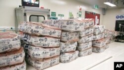FILE - Packages of cocaine sit at a facility in Sydney, Australia, in this undated photo provided by Australian Federal Police.