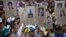 FILE - Demonstrators hold up posters with images of Venezuelans who were killed in the past two weeks during the recent unrest, at a rally with human rights activists in Caracas, Venezuela, Feb. 28, 2014.