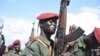 A South Sudanese government army soldier slaps his gun at Jebel Makor, 45 minutes outside South Sudan's capital Juba, April 14, 2016. (Credit: Jason Patinkin)