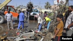 Street cleaners remove debris on the road after a car bomb exploded in Diwaniya province, 150 km (95 miles) south of Baghdad, April 29, 2013.