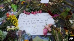 FILE - Notes and flowers form a memorial in Charlottesville, Virginia, Aug. 18, 2017, at the site where Heather Heyer was killed. Heyer was struck by a car while protesting a white nationalist rally on Aug. 12.