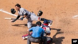 Miguel Rojas (izq.) de los Marlins de Miami, reacciona tras ser golpeado por una pelota en el séptimo episodio de un juego contra los Filis el domingo 26 de julio de 2020, en Filadelfia.