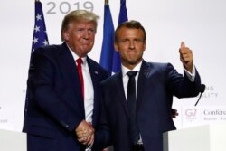 FILE - U.S President Donald Trump, left, and French President Emmanuel Macron shake hands after their joint press conference at the G-7 summit, Aug. 26, 2019 in Biarritz, France.