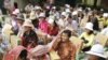 People sit as they receive flood donations at downtown Phnom Penh, Thursday, Oct. 13, 2011. 