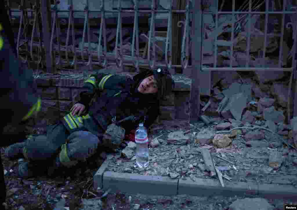 A rescuer rests after works at a site of apartment buildings hit by a Russian air strike in Kherson, Ukraine, Feb. 2, 2025.