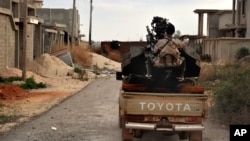 Un homme des forces armées libyennes se prépare à combattre des membres du groupe Etat islamique à l'ouest de Benghazi, Libye, le 7 mars 2016.