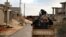 FILE - a man loyal to the Libyan armed forces prepares himself for clashes with Islamic State group militants west of Benghazi, Libya.