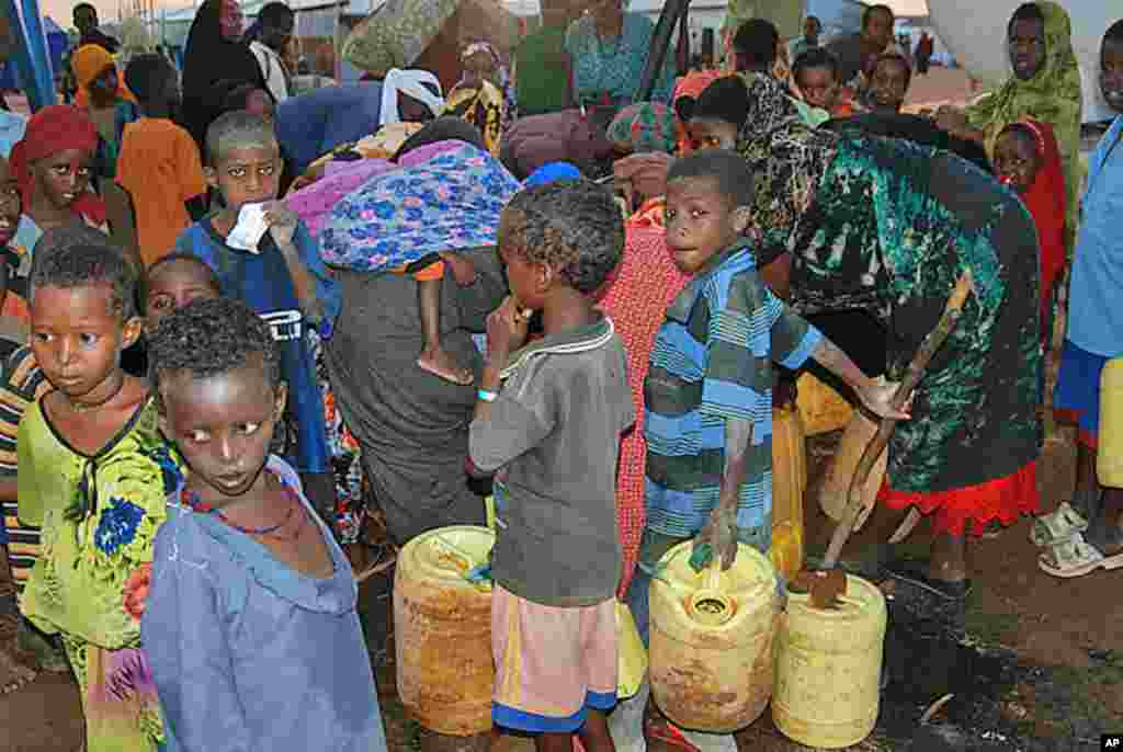Women and children crowd around the public water taps at the Dollo Ado refugee transit facility in Ethiopia, October 26, 2011. (VOA - P. Heinlein)