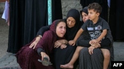 Perempuan dan anak-anak menangis saat pemakaman pria yang tewas akibat serangan udara Israel di sekolah Jawni di Nuseirat, Deir el-Balah, Jalur Gaza, pada 12 September 2024. (Foto: AFP)