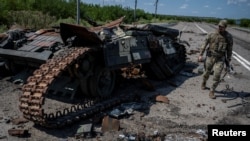 지난해 8월 우크라이나군 병사가 자포리자 지역 로보티네 외곽에서 파괴된 탱크를 살피고 있다. (자료사진)