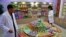 In this Oct. 22, 2018, photo, Kwon Yong Chol, left, the chief engineer at the Songdowon General Foodstuffs Factory, shows samples of products at his facility in Wonsan, North Korea. 
