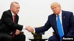 Presiden Turki Recep Tayyip Erdogan (kiri) berjabat tangan dengan Presiden AS Donald Trump dalam pertemuan di KTT G20 di Osaka, Jepang 29 Juni 2019 lalu. 