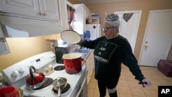 Nancy Wilson, de Houston, Texas, hierve agua en su casa siguiendo instrucciones de las autoridades luego de una tormenta invernal que ha roto tuberías y ha dejado sin servicio de agua potable a muchos residentes. Febrero 19 de 2021.