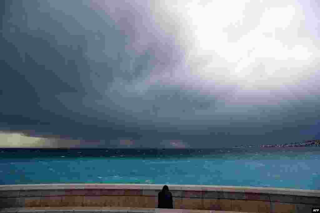 A man looks at an approaching storm in Nice, southeastern France.