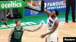 Joel Embiid des Philadelphia 76ers dunk contre les Boston Celtics, USA, le 6 avril 2021. 