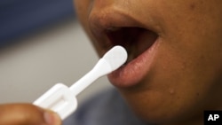 Katherine Tapp, 26, of New York City uses an oral test for HIV inside the HIV Testing Room at the Penn Branch of the District of Columbia Department of Motor Vehicles, in southeast Washington, June 27, 2012.