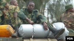 An M23 soldier rests on boxes of ammunition as the group withdraws from the Congolese city of Goma, Dec. 1, 2012 (photo - VOA/G. Joselow).