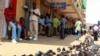 FILE - In an earlier tax protest, vendors sell used shoes on the street outside their shops in Kampala, Uganda, June 28, 2013. 