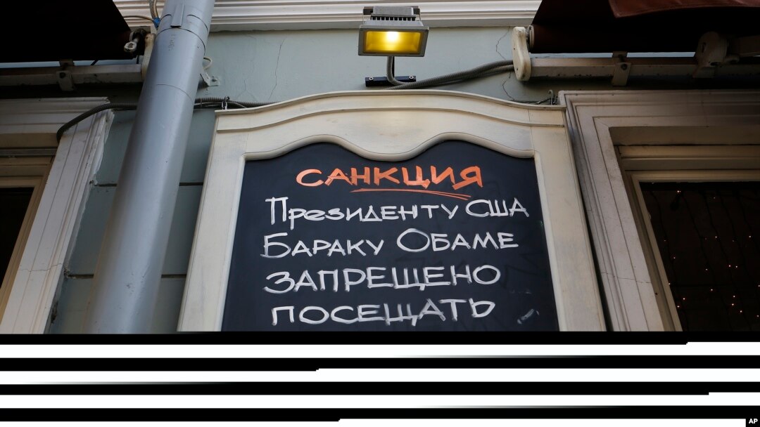 Papan bertuliskan "Sanksi. Presiden AS Barack Obama dilarang masuk Restoran Dolma!" di Moskow, Rusia, Maret 2014.
