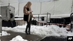 Seorang perempuan memeriksa telepon selularnya di luar Lincoln Center, tempat berlangsungnya acara mode New York's Fashion Week (9/2). (AP/Richard Drew)