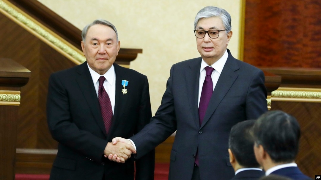 Kazakhstan's President Kassym-Jomart Tokayev, right, and outgoing Kazakh President Nursultan Nazarbayev shake hands after Tokayev's inauguration in Astana, Kazakhstan, March 20, 2019.