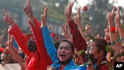Protesters flash the three-fingered salute in Yangon, Myanmar, Feb. 7, 2021. Thousands of people rallied against the military takeover and demanded the release of Aung San Suu Kyi.