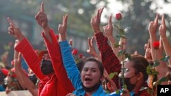 Protesters flash the three-fingered salute in Yangon, Myanmar, Feb. 7, 2021. Thousands of people rallied against the military takeover and demanded the release of Aung San Suu Kyi.