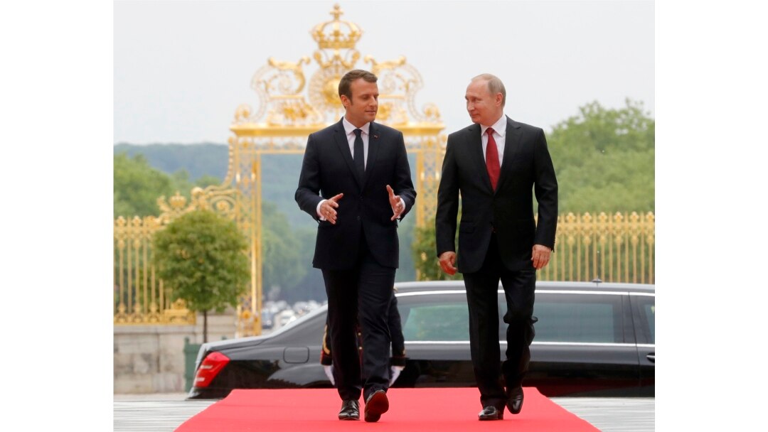 FILE - President Emmanuel Macron and his Russian counterpart Vladimir Putin walk, as they meet for talks before the opening of an exhibition marking 300 years of diplomatic ties between the two countries at Palace of Versailles, May 29, 2017.