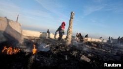 Palestinians inspect the site of an Israeli strike on a beachfront cafe, amid the ongoing conflict between Israel and Hamas, in Deir Al-Balah in the central Gaza Strip, Jan. 14, 2025.