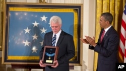 미군 군종 신부로 참전한 에밀 카폰 신부의 조카 레이먼드 카폰 씨가 지난 2013년 4월 바락 오바마 당시 대통령이 카폰 신부에게 추서한 ‘명예훈장(Medal of Honor)’을 들고 있다. 