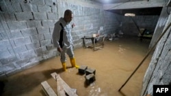 FILE —A man stands in the flooded basement of a home in Libya's coastal city of Zliten, 150 kilometers east of the capital on February 13, 2024, as a result of rising groundwater levels. 