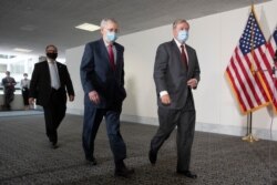 FILE - Senate Republican Majority Leader Mitch McConnell, left, and Republican Sen. Lindsey Graham, both wearing face masks to protect against the coronavirus, walk on Capitol Hill, in Washington, May 19, 2020.