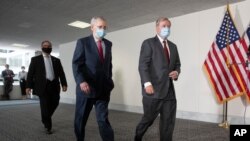 FILE - Senate Republican Majority Leader Mitch McConnell, left, and Republican Sen. Lindsey Graham, both wearing face masks to protect against the coronavirus walk on Capitol Hill, in Washington, May 19, 2020. 