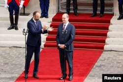 FILE - Former French Prime Minister Edouard Philippe applauds newly appointed Prime Minister Jean Castex in the courtyard of the Matignon Hotel during the handover ceremony in Paris, France, July 3, 2020.