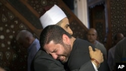 L'imam Samir Abdel Bary, présente ses condoléances à Tarek Abu Laban, au centre, éploré par la disparition quatre parents dans l’accident de l’avion EgyptAir, au mosquée al Thawrah, au Caire, en Egypte, vendredi 20 mai 2016. (AP Photo / Amr Nabil)