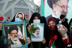 FILE - Supporters of Iranian President-elect Ebrahim Raisi celebrate after he won the presidential election in Tehran, Iran, June 19, 2021.