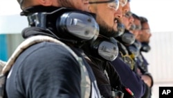 A SWAT team from Iraq's Anbar province watches U.S. instructors staging a training drill on how to respond to a bomb threat and how to detonate the device at the Jordan International Police Training Center, in the Jordanian town of al-Muwaqqar, about 34 m