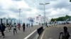 FILE - People run away from tear gas during a protest on the street in Kano, Nigeria, Aug. 1, 2024. 